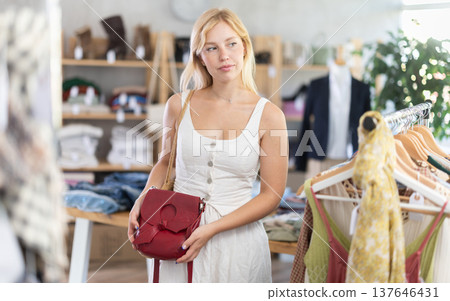 Young women choosing handbag in store Young women choosing handbag in store 137646431