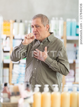 Senior man visits pharmacy and suffers from cough Senior man visits pharmacy and suffers from cough 137646436