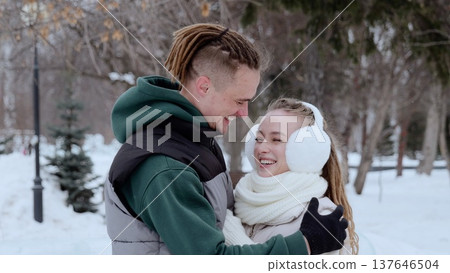 Multicultural couple laughing, hugging during snowy winter park stroll, sharing warm intimate moment together Multicultural couple laughing, hugging during snowy winter park stroll, sharing warm intimate moment together 137646504