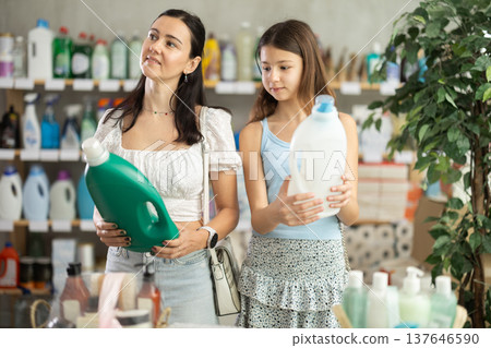 Woman with daughter choosing detergent in store 137646590