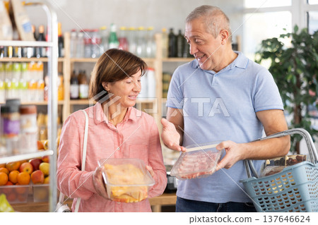 Couple elderly man and woman choosing chicken and pork Couple elderly man and woman choosing chicken and pork 137646624