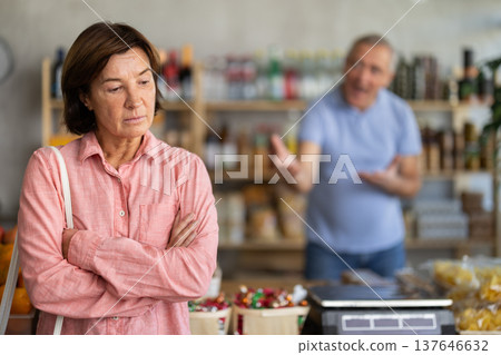 Family quarrel between elderly husband and wife in grocery supermarket. Husband screams at her wife Family quarrel between elderly husband and wife in grocery supermarket. Husband screams at her wife 137646632