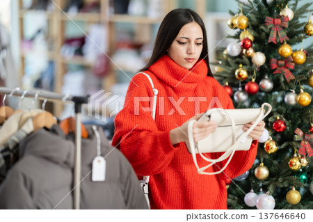 Young woman choosing handbag in store 137646640