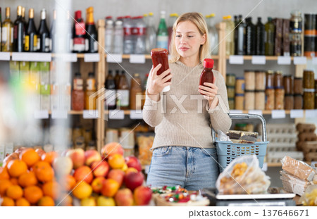Young woman choosing ketchup in grocery store 137646671