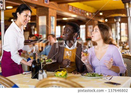 Asian waitress brought tray with restaurant guests Asian waitress brought tray with restaurant guests 137646802