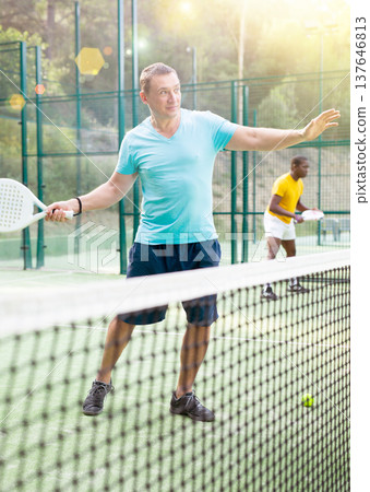 Man playing padel tennis on court Man playing padel tennis on court 137646813