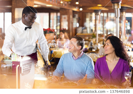Man and woman talking with waiter in restaurant Man and woman talking with waiter in restaurant 137646898