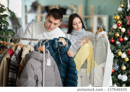 Young couple choosing coat or jacket in clothing store 137646930
