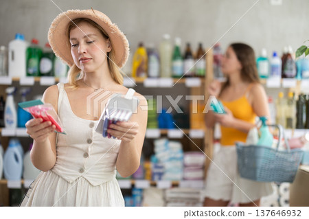 Interested girl choosing disposable razors in supermarket Interested girl choosing disposable razors in supermarket 137646932