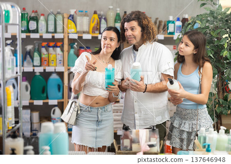 Teenage girl with parents choosing shower gel in personal care store Teenage girl with parents choosing shower gel in personal care store 137646948