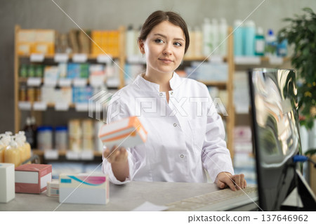 Female pharmacist standing at drugstore with medical product in hands Female pharmacist standing at drugstore with medical product in hands 137646962