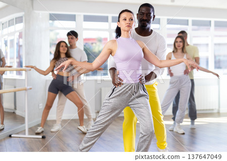 Woman with African man dancing waltz in couple during lesson at studio Woman with African man dancing waltz in couple during lesson at studio 137647049
