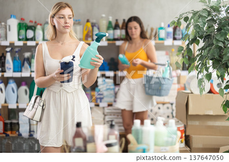 Woman holding cleaning sprays in her hands in store 137647050