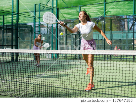 Two women tennis players playing padel 137647193