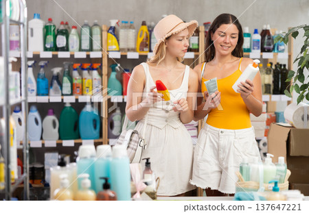 Two friends girls view trademark sign on label, pick eco friendly sunblock cream Two friends girls view trademark sign on label, pick eco friendly sunblock cream 137647221
