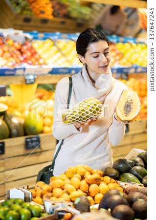 In vegetable store, young woman customer buy papaya 137647245
