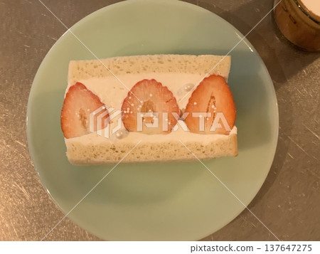 Japanese fruit sando with fluffy white bread, fresh cream, and vibrant slices of seasonal fruits like strawberries, kiwis, and mangoes. A refreshing, colorful treat perfect for any occasion. 137647275