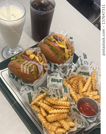 A classic combination of a juicy burger with fresh toppings served alongside golden, crispy French fries. Perfect for a satisfying meal that blends savory flavors and crunchy textures. A classic combination of a juicy burger with fresh toppings served alongside golden, crispy French fries. Perfect for a satisfying meal that blends savory flavors and crunchy textures. 137647331