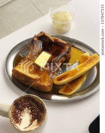 Golden, fluffy French toast with a crisp edge and soft center, topped with syrup, fruits, or powdered sugar. Offering a perfect balance of sweetness, warmth, and comfort in every delightful bite. 137647333
