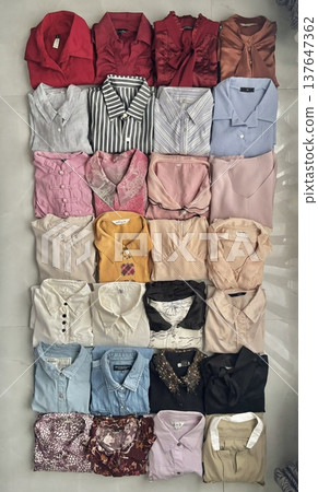 Stack of neatly folded clothes in various colors and fabrics, showing layered textures, soft materials, and stylish casual outfits prepared for daily wear, highlighting a trendy OOTD concept in detail Stack of neatly folded clothes in various colors and fabrics, showing layered textures, soft materials, and stylish casual outfits prepared for daily wear, highlighting a trendy OOTD concept in detail 137647362