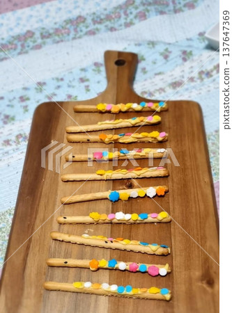 Pepero sticks coated with chocolate and sometimes topped with nuts or sprinkles. A sweet and crunchy treat, perfect for sharing or gifting on special occasions. 137647369