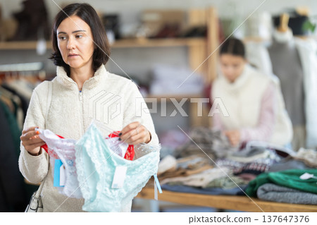 Adult woman chooses panties in clothing store Adult woman chooses panties in clothing store 137647376