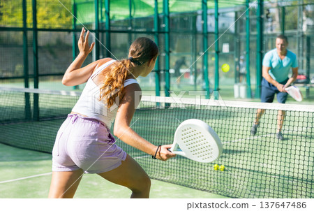 European woman tennis player in padel tennis playing on the outdoor court 137647486