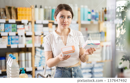 Young girl reviewing labels of prescribed medication in pharmacy 137647492