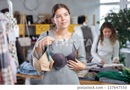 Girl chooses bra in fashionable clothing boutique Girl chooses bra in fashionable clothing boutique 137647550