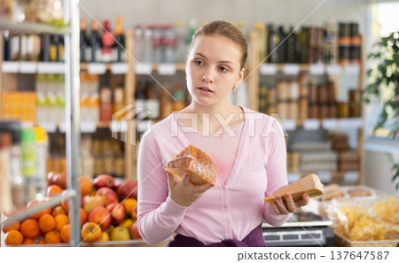 Choose cheese in supermarket - woman chooses what cheese to buy in the dairy department section of store Choose cheese in supermarket - woman chooses what cheese to buy in the dairy department section of store 137647587