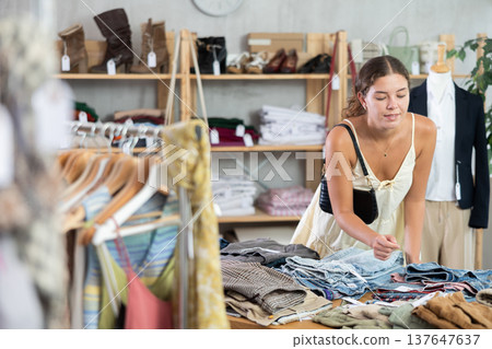 Young woman choosing jeans Young woman choosing jeans 137647637