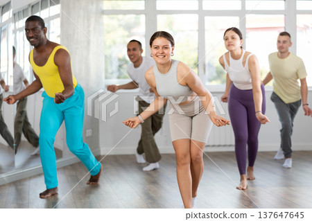 Young fit girl energizing group during dance fitness class 137647645