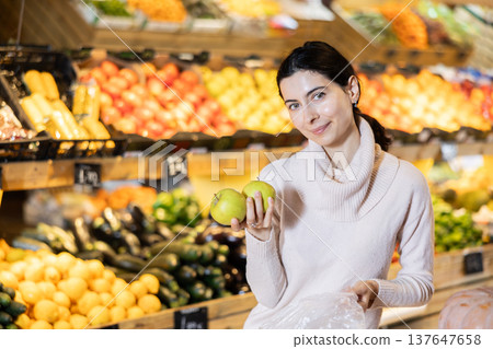 Young woman choosing apples in vegetable shop Young woman choosing apples in vegetable shop 137647658