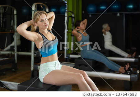 Woman doing bends on a reformer Woman doing bends on a reformer 137647688