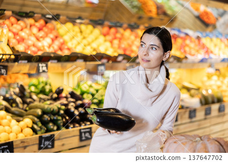 Young woman choosing eggplants in vegetable shop Young woman choosing eggplants in vegetable shop 137647702
