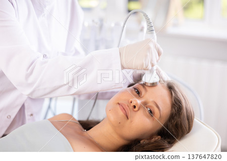 Young woman undergoing high frequency ultrasound facial treatment 137647820