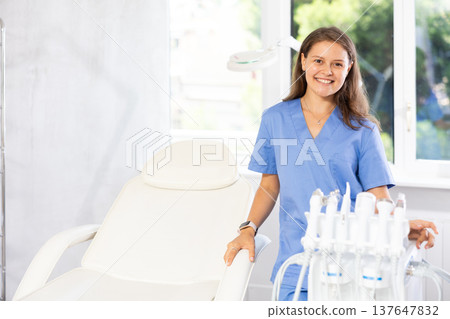 Young woman doctor posing with cosmetology apparatus Young woman doctor posing with cosmetology apparatus 137647832