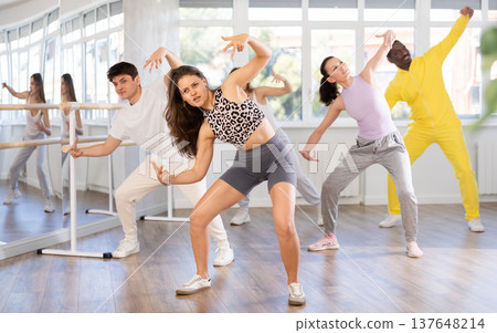 Girl with team of young like-minded people learn to dance modern dances Girl with team of young like-minded people learn to dance modern dances 137648214