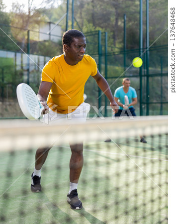 Man playing padel tennis on court Man playing padel tennis on court 137648468