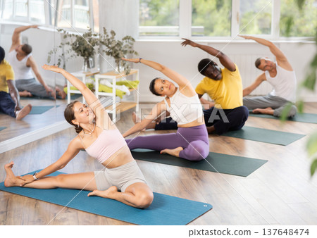 Group of men and women doing yoga in studio 137648474