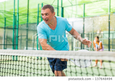Man training to play tennis on padel court outdoor Man training to play tennis on padel court outdoor 137648494