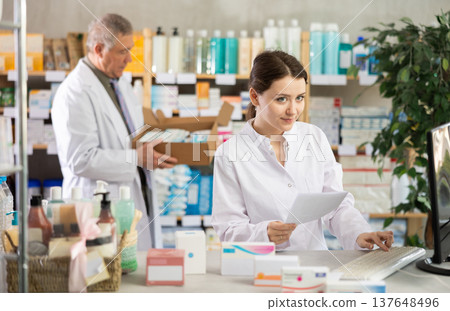 Female pharmacist checking prescription on computer Female pharmacist checking prescription on computer 137648496