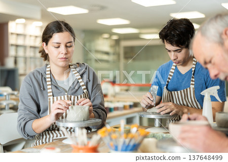 Young woman and man and elderly man crafting ceramics Young woman and man and elderly man crafting ceramics 137648499