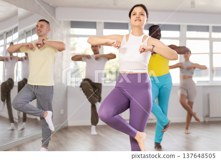 Young Asian woman practicing energetic dance at group class Young Asian woman practicing energetic dance at group class 137648505