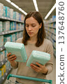 Woman choosing baby diapers in supermarket aisle 137648760