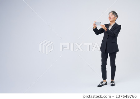 操作智能手機的資深婦女 操作智能手機的資深婦女 137649766