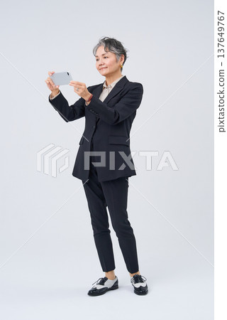 操作智能手機的資深婦女 操作智能手機的資深婦女 137649767
