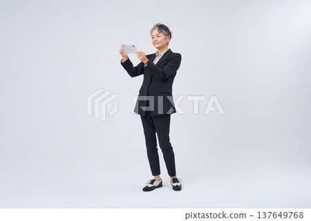 操作智能手機的資深婦女 137649768