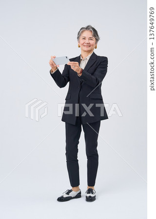 操作智能手機的資深婦女 操作智能手機的資深婦女 137649769