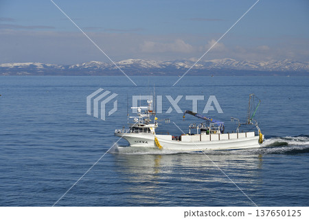 A photograph of fishing boats returning to Otobe Fishing Port in Yakumo Town, Hokkaido, in early spring. A photograph of fishing boats returning to Otobe Fishing Port in Yakumo Town, Hokkaido, in early spring. 137650125